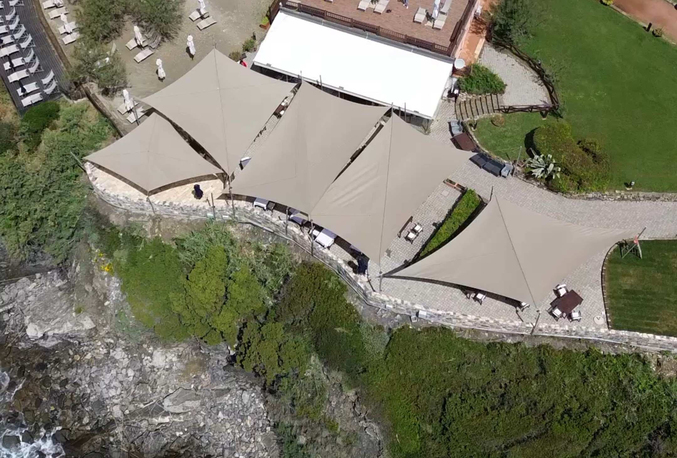Vela da sole manuale Tralli, Modello M, disposizione diagonale su patio con colonne