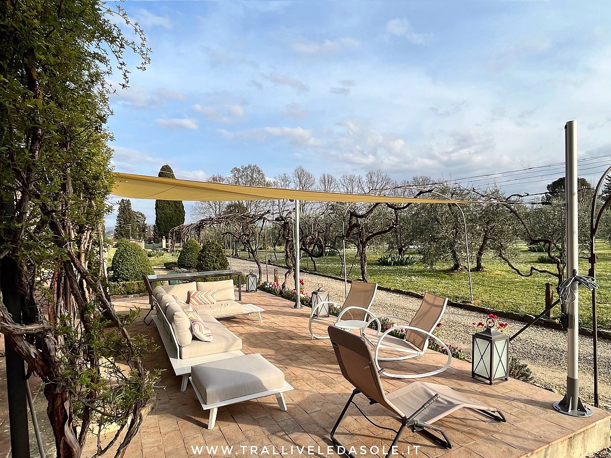 Vela avvolgibile manuale sopra una terrazza con sdraio e ulivi a Firenze