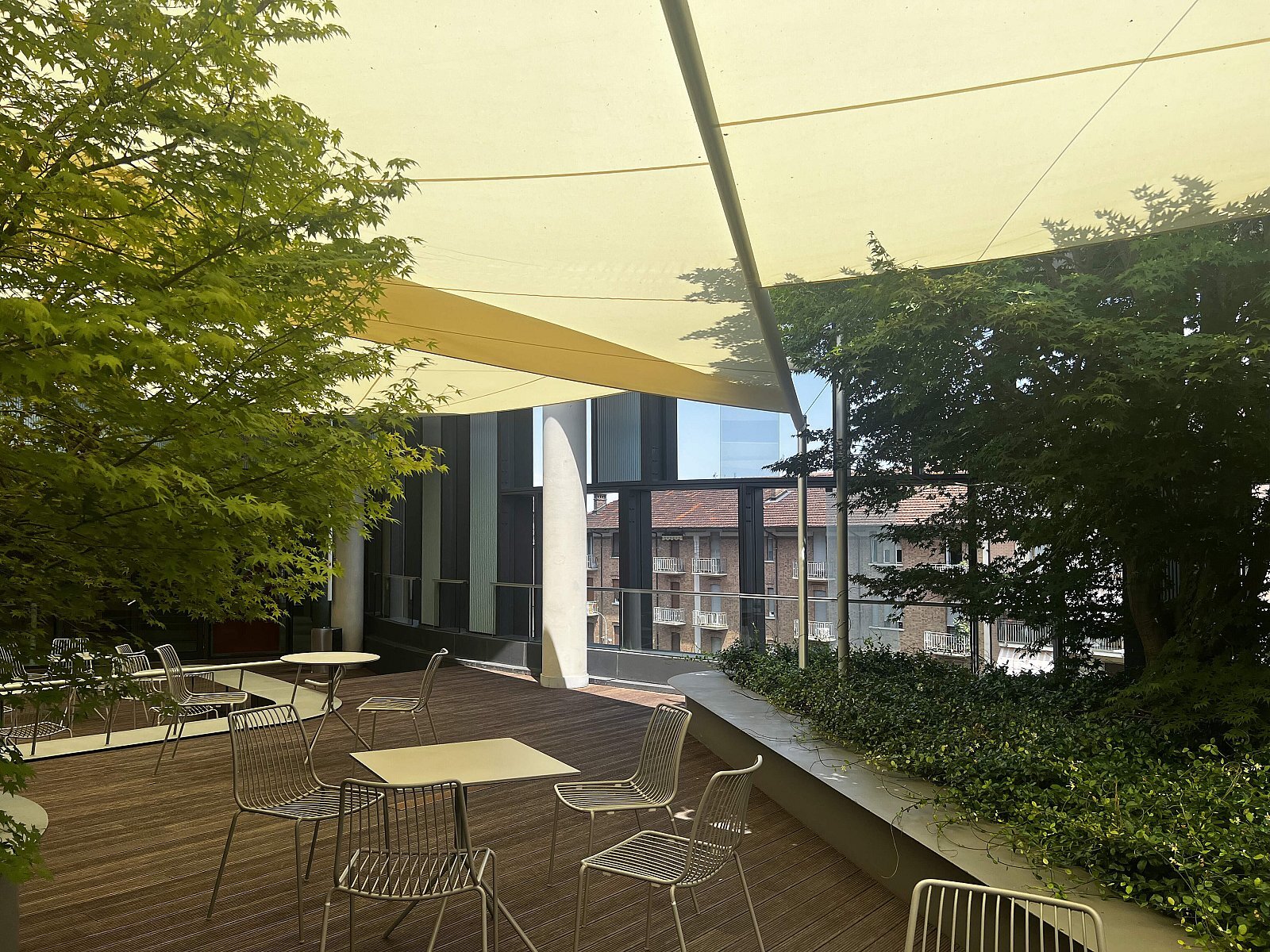 Zona lounge outdoor ombreggiata da vele da sole alla Nuvola Lavazza, Torino