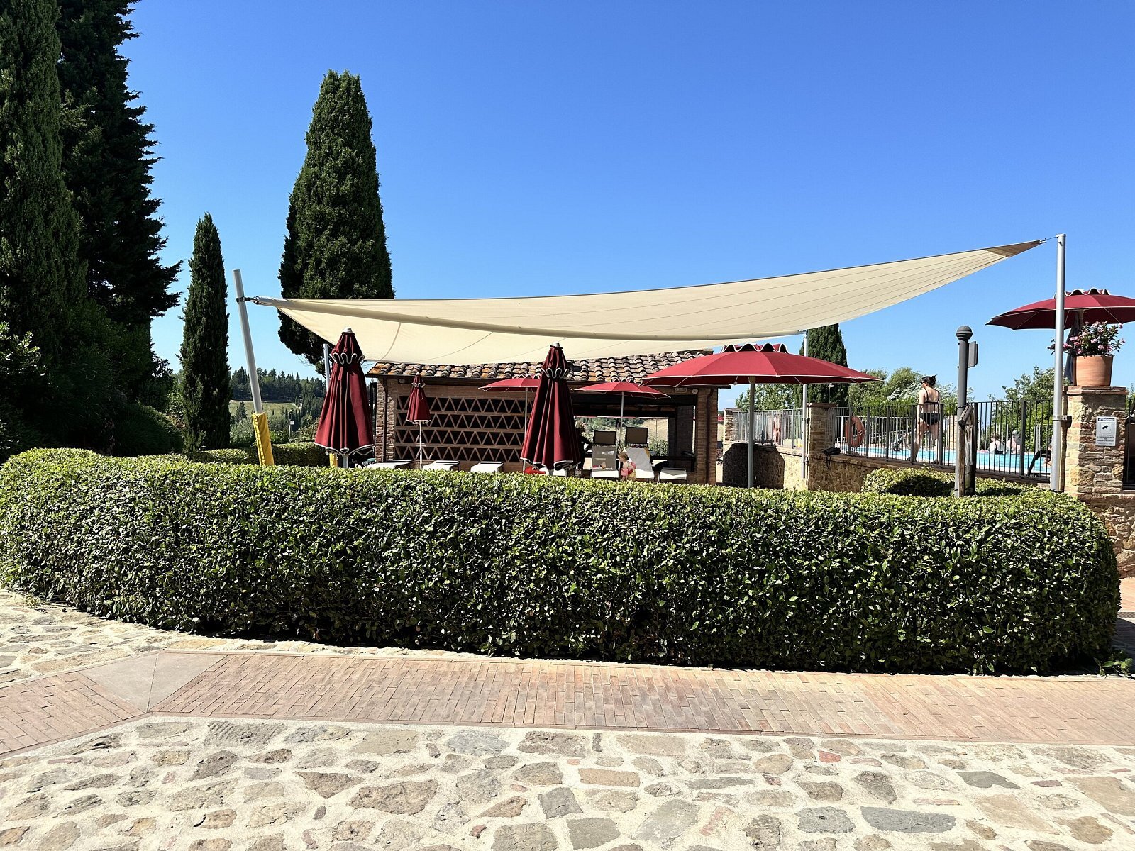 Hapimag Resort Tonda, Montaione: la vela avvolgibile motorizzata con siepe e cipressi sullo sfondo