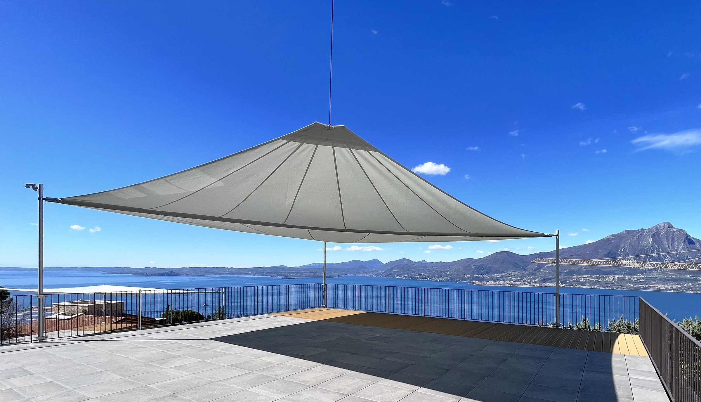 Vela avvolgibile motorizzata aperta su una terrazza affacciata sul Lago di Garda