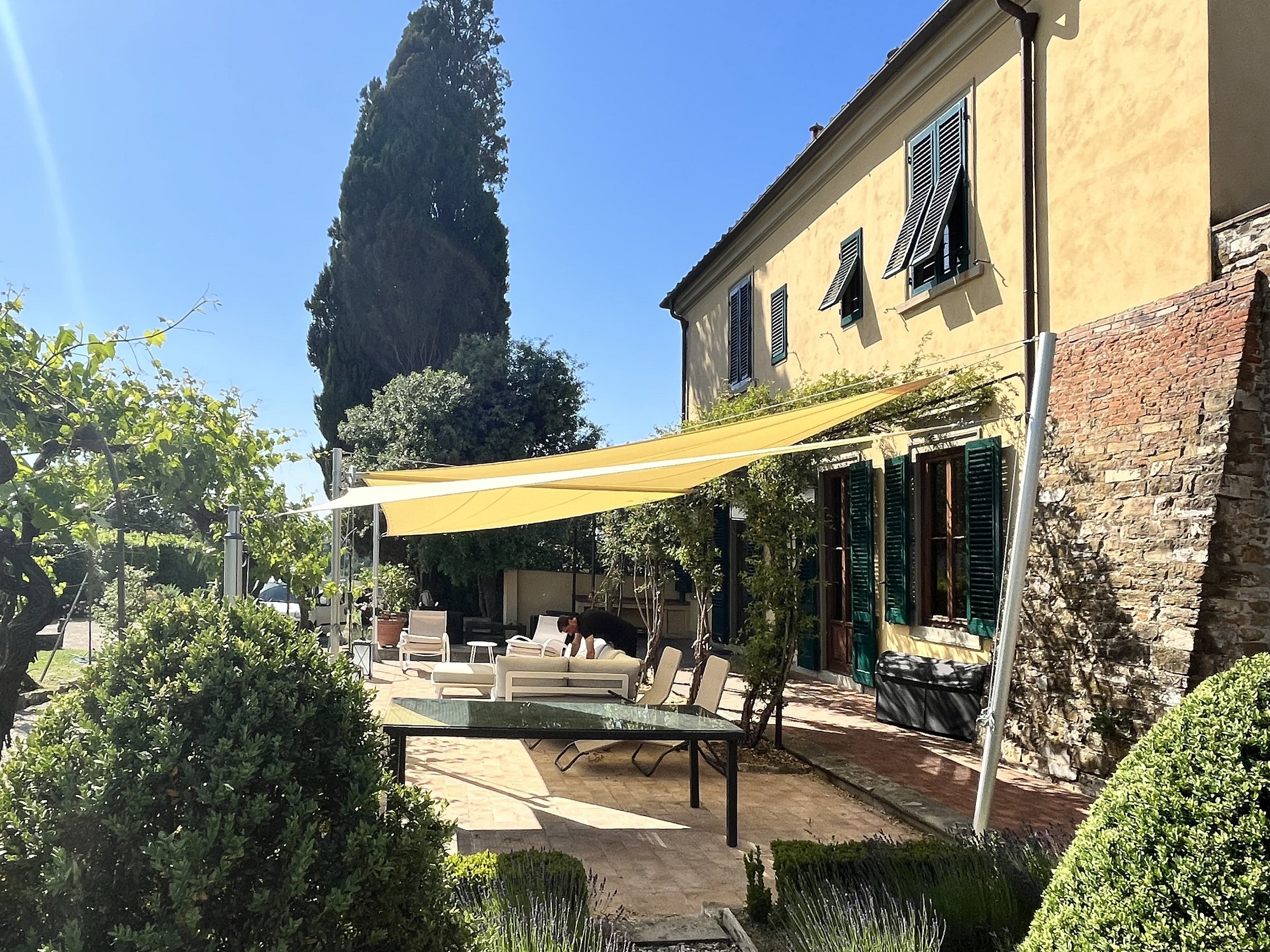 Vela avvolgibile manuale Modello A sopra il giardino di una villa
