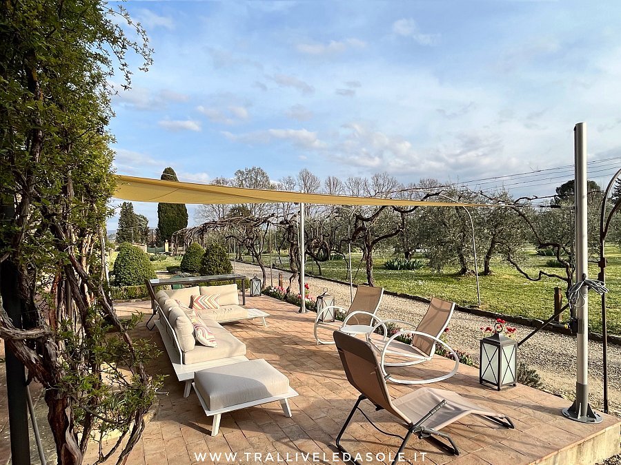 Vela da sole sopra una terrazza con sdraio tra gli ulivi a Firenze